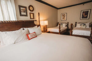 A charming bedroom featuring vintage-style beds and classic wall art.