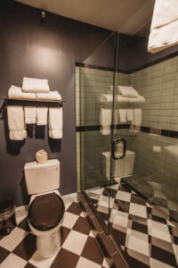 Clean bathroom featuring a glass shower enclosure, towels, and a toilet.