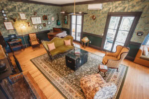 A vintage-style living room featuring a piano, musical instruments, and eclectic furniture.