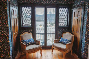 A charming sitting area with two vintage armchairs and a balcony view.
