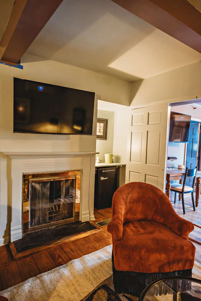 Living room with fireplace, TV, and comfortable armchair.