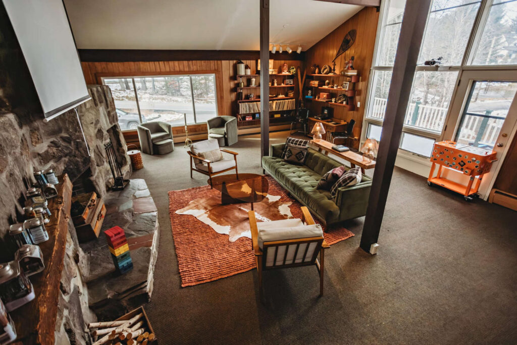 Interior view of a cozy hotel lounge featuring large windows, comfortable seating, and a fireplace.