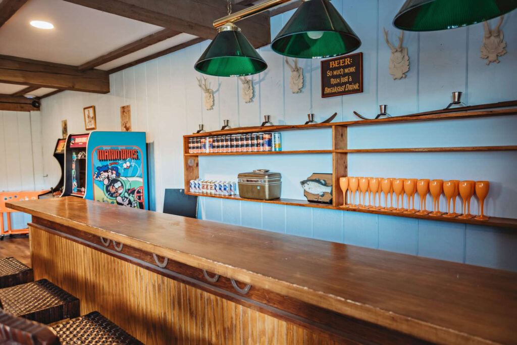 A welcoming bar area with green pendant lights, wooden accents, and beer taps.