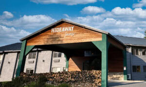 Exterior view of Hideaway Inns with wooden and green accents.