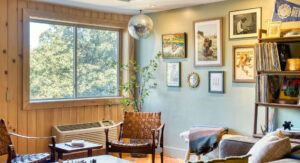 Bright living room featuring artwork, books, and a large window.