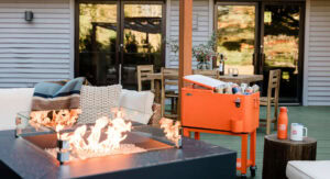 Outdoor patio featuring a fire pit, seating area, and a cooler with drinks.