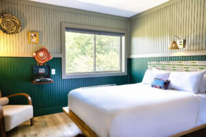 Bright hotel room with a large window overlooking greenery.
