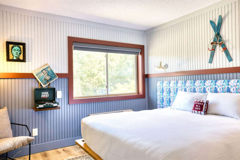 Bright inn room featuring a large window, vintage wall art, and ski decor.