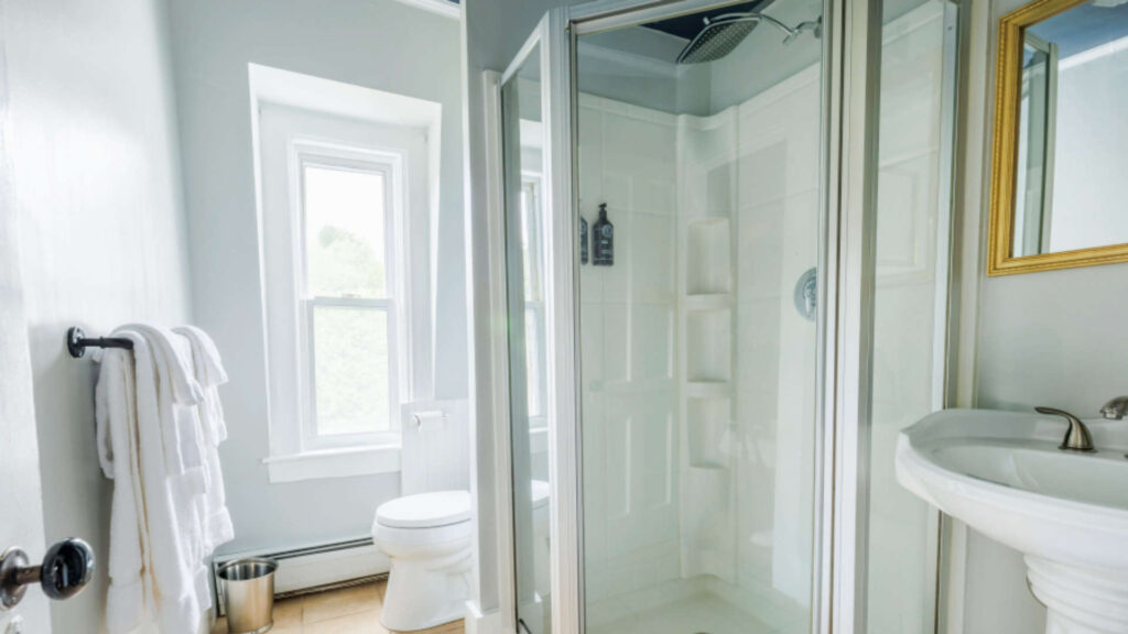 Bright bathroom with shower, toilet, and window in a hotel.